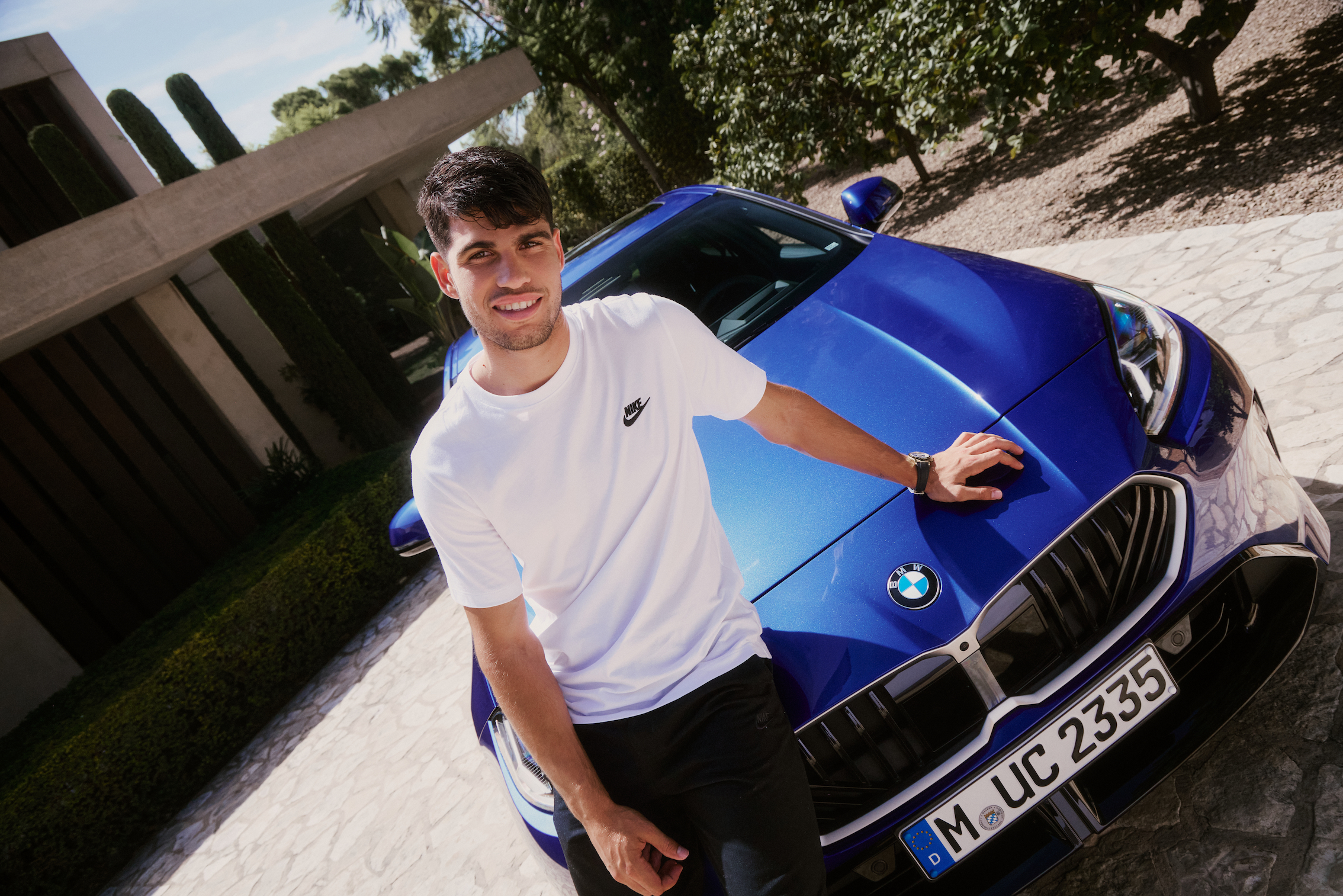 Alcaraz sentado en el capo del nuevo BMW