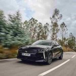 DS 9 E-Tense Long Range negro circulando por carretera, mostrando su diseño y elegancia.