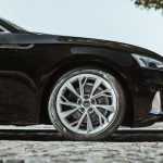 Neumático de turismo montado en un vehículo moderno circulando en entorno urbano.