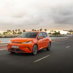 BYD DOLPHIN G DM-i híbrido enchufable circulando junto al puerto.