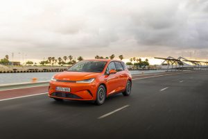 BYD DOLPHIN G DM-i híbrido enchufable circulando junto al puerto.