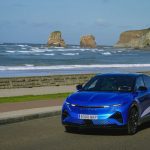 Alpine A390 GT azul circulando junto al puerto durante un viaje de verano.