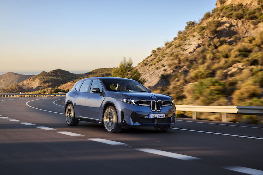 BMW IX3 circulando por carretera de montaña.