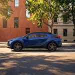 Toyota C-HR Hybrid azul circulando por una avenida urbana.