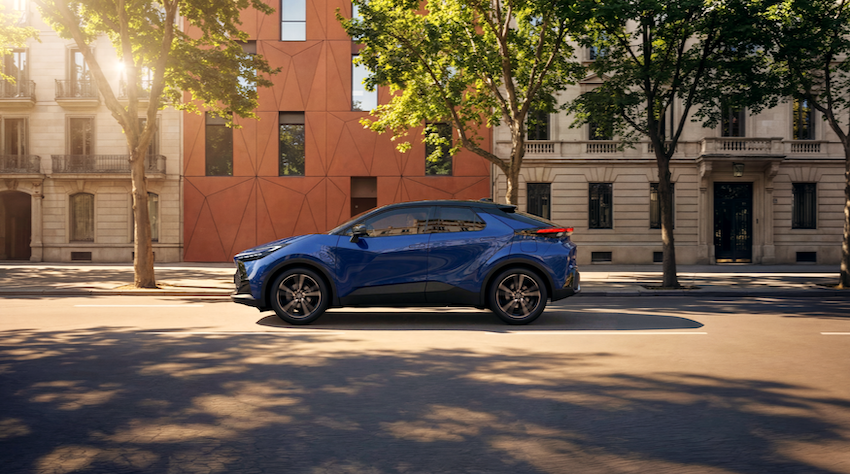 Toyota C-HR Hybrid azul circulando por una avenida urbana.